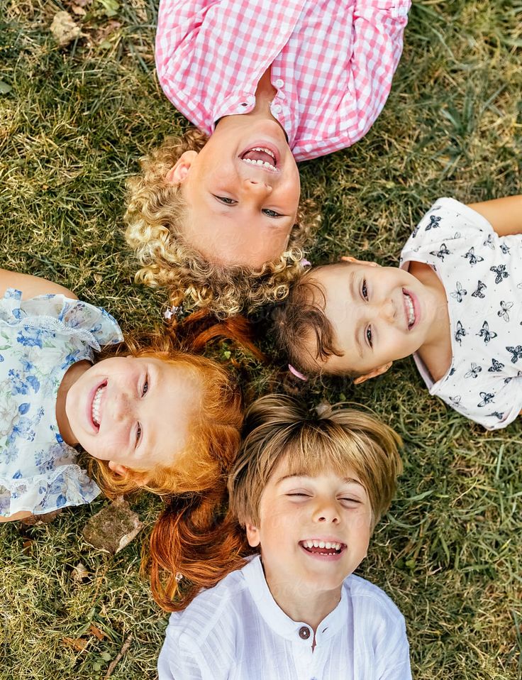 _Four Smiling Children Lying On The Grass_ by Stocksy Contributor _Marco Govel_
